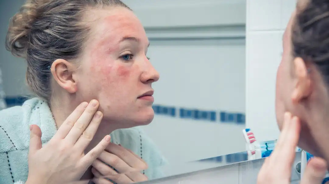 Woman examining facial skin in a mirror illustrating oxidative stress and skin changes