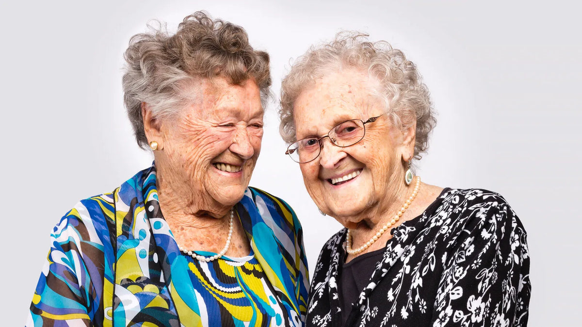 Portrait of identical twin women illustrating how skin appearance can vary with age and environmental exposure.