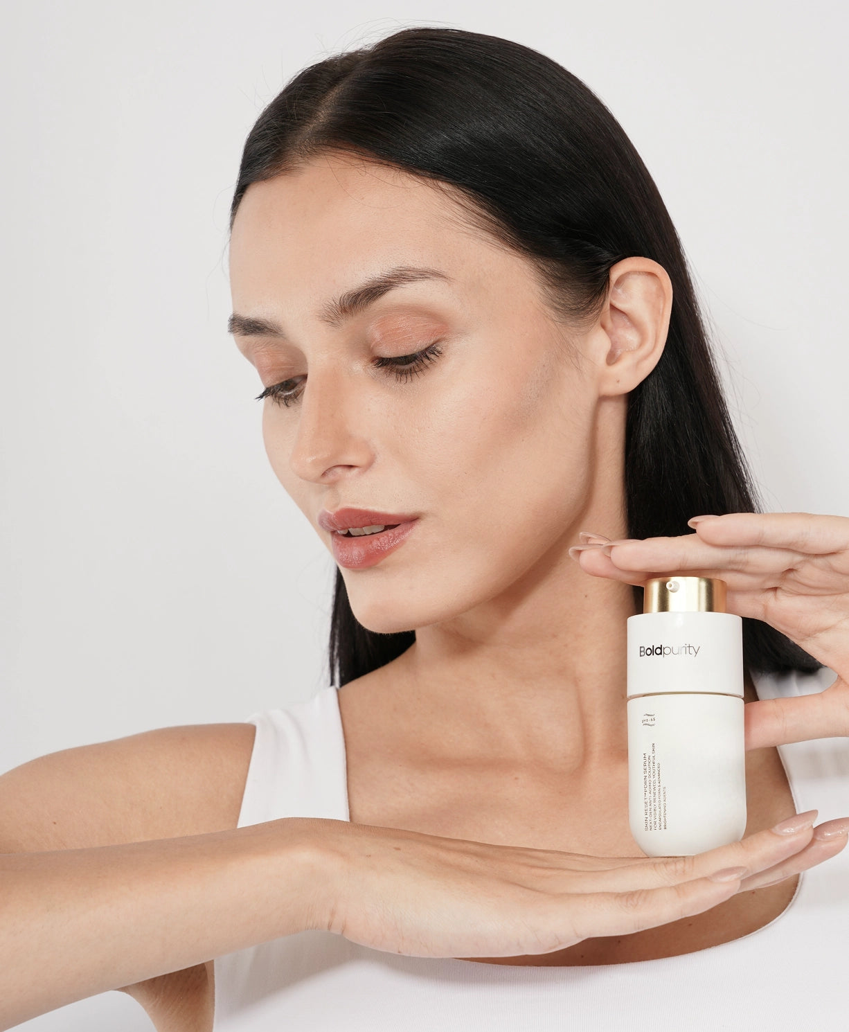 Model holding a bottle of SkinReset PDRN Serum in hand.